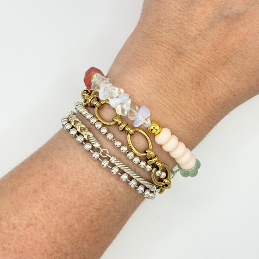 Close-up of a wrist wearing multiple bracelets on a white background