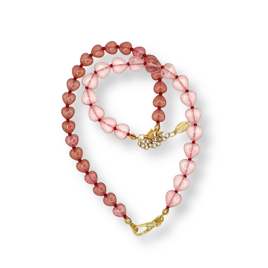 Beaded necklace with pink and gold elements on a white background