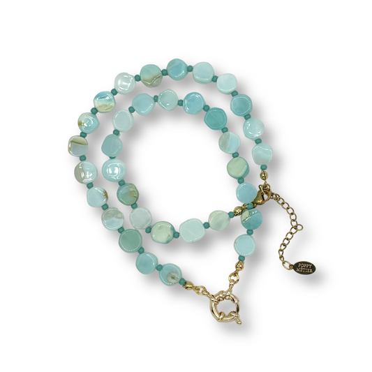 Turquoise beaded necklace with a gold chain on a white background