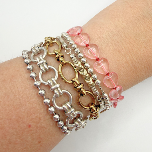 Three bracelets on a wrist against a white background