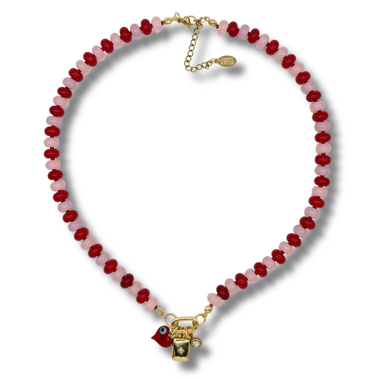 Necklace with red and pink beads and a gold clasp on a white background